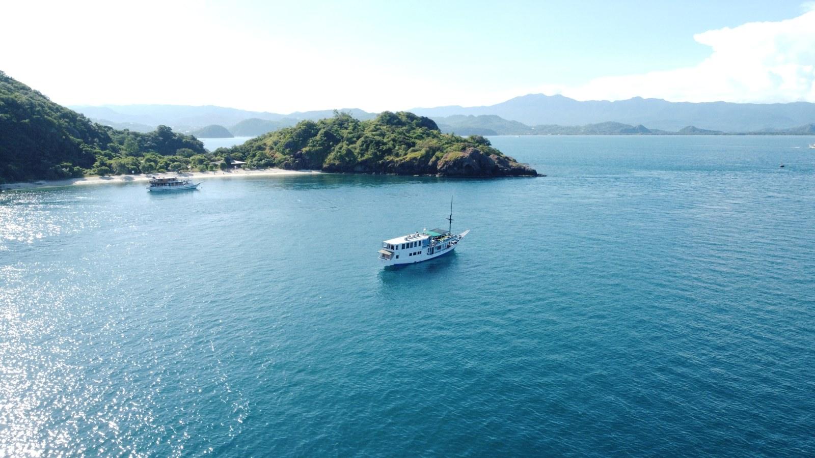 Princess Lala in a wide bay with a white-sand beach behind