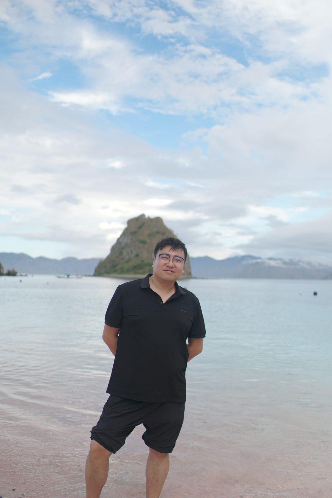 Kelor – man standing in shallows, islet behind (Echtes Foto von einer Komodo-Explorer-Fahrt)