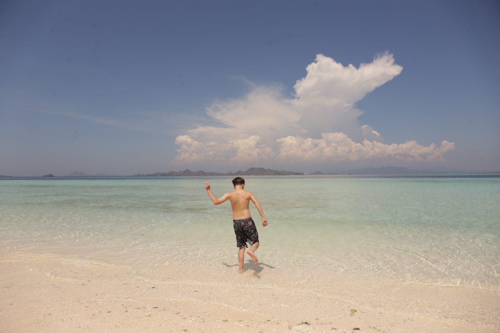 Taka Makassar – man walking on sandbar, cloud behind (Echtes Foto von einer Komodo-Explorer-Fahrt)