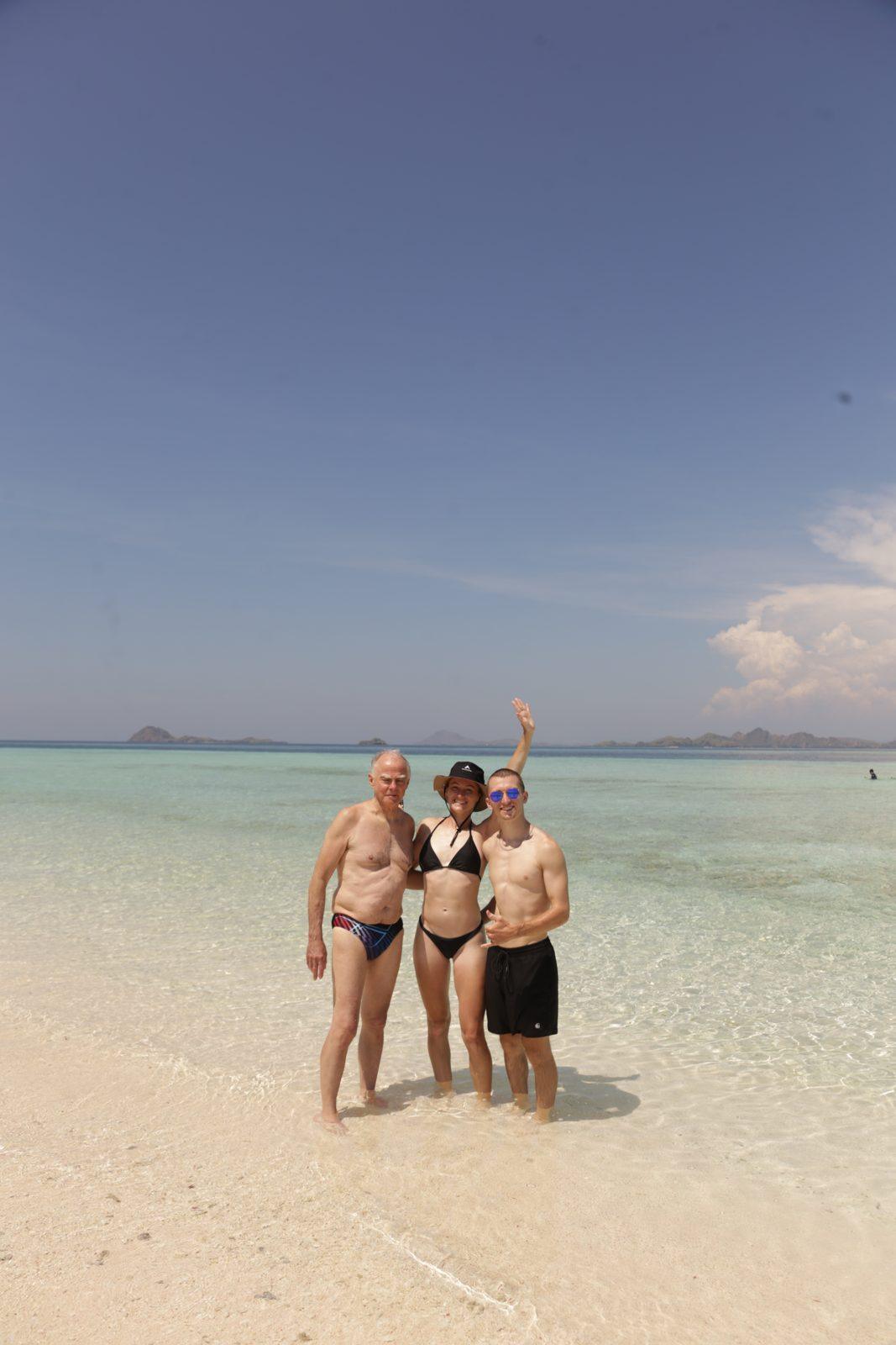 Taka Makassar – group on sandbar, arms raised (Echtes Foto von einer Komodo-Explorer-Fahrt)